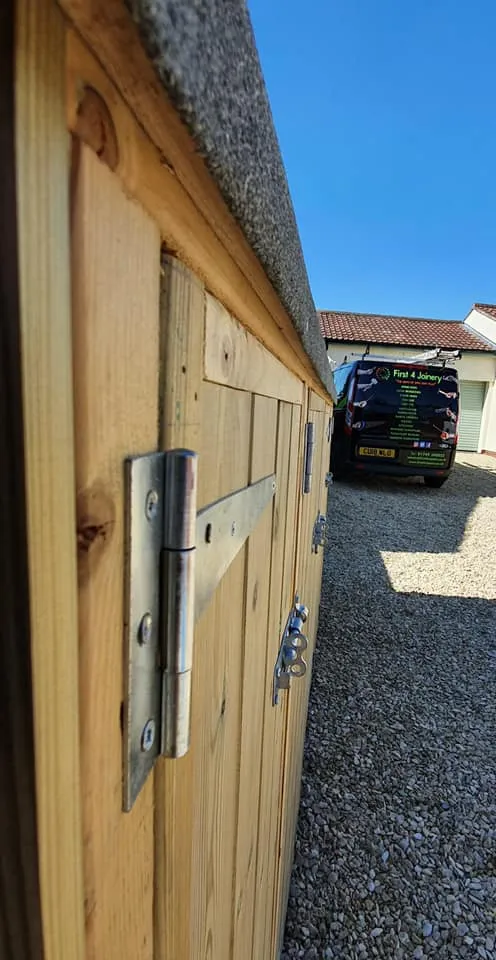 A car parked in a driveway next to a wooden fence.