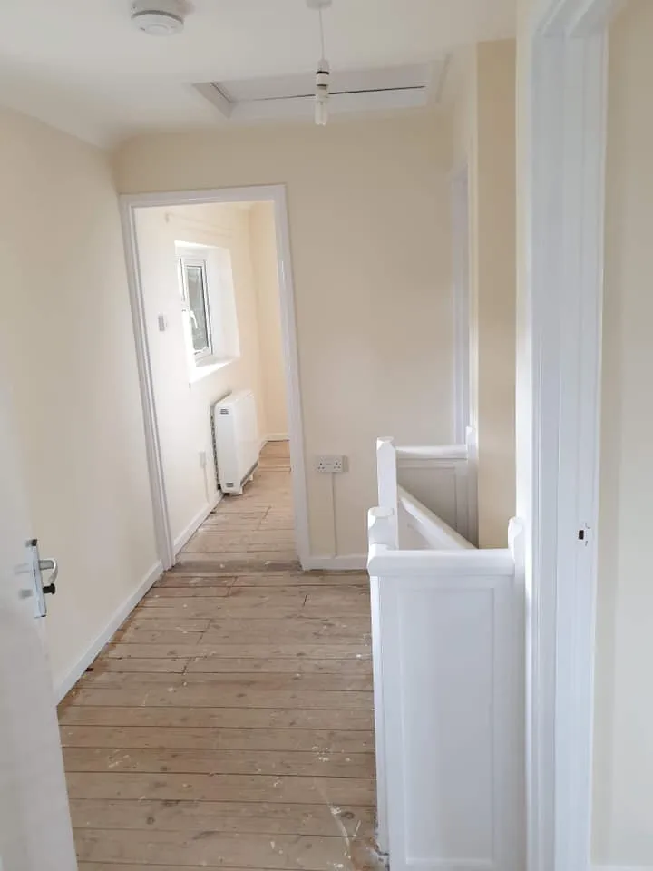 A hallway with a white door and a white radiator.