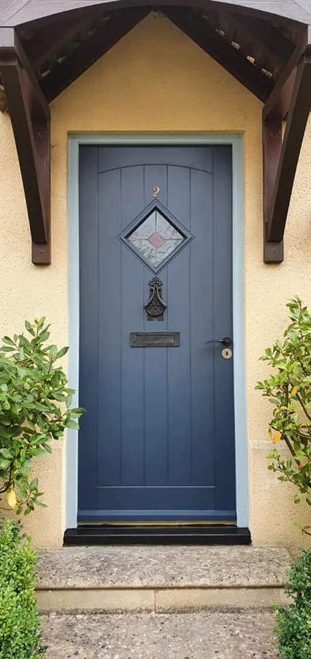 A blue front door with a brown roof.