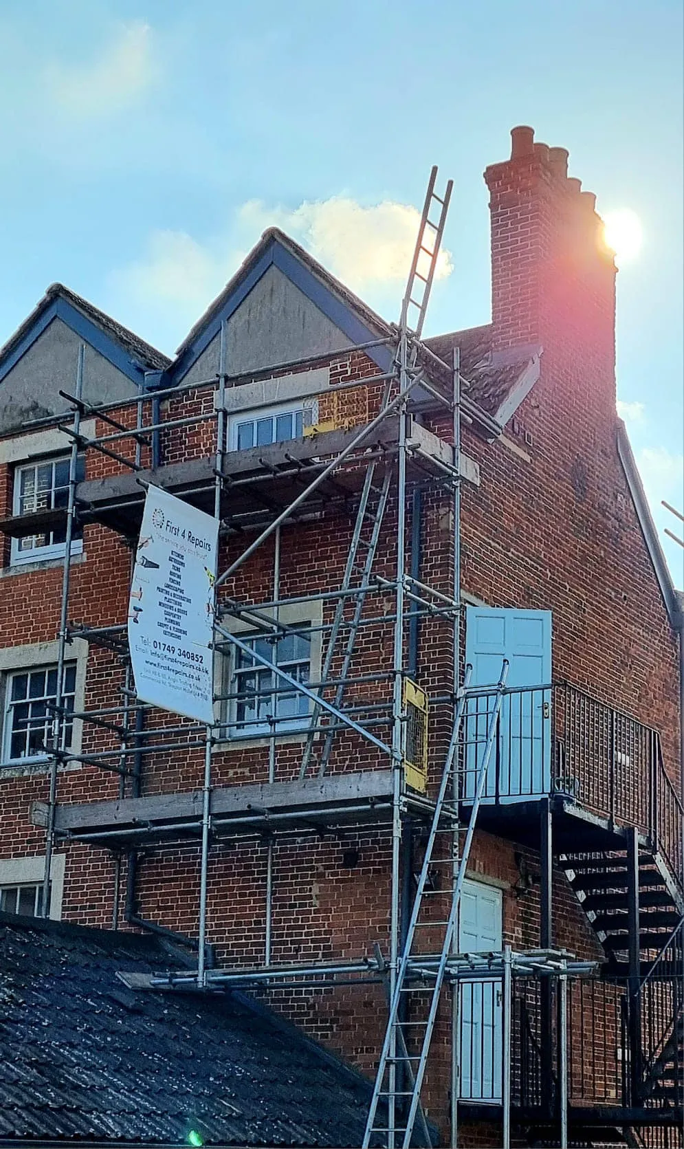 A brick building with scaffolding and a fire escape.