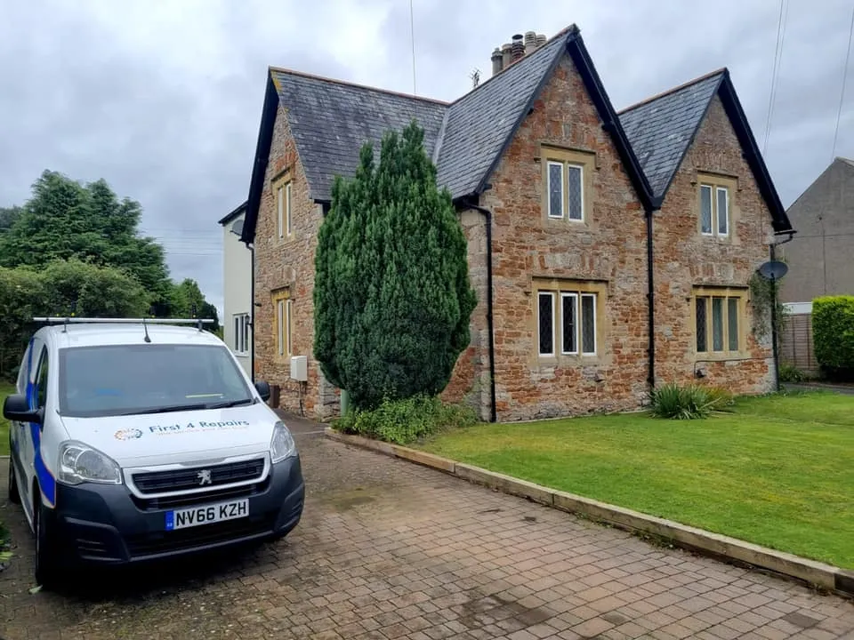 A van parked in front of a brick house.