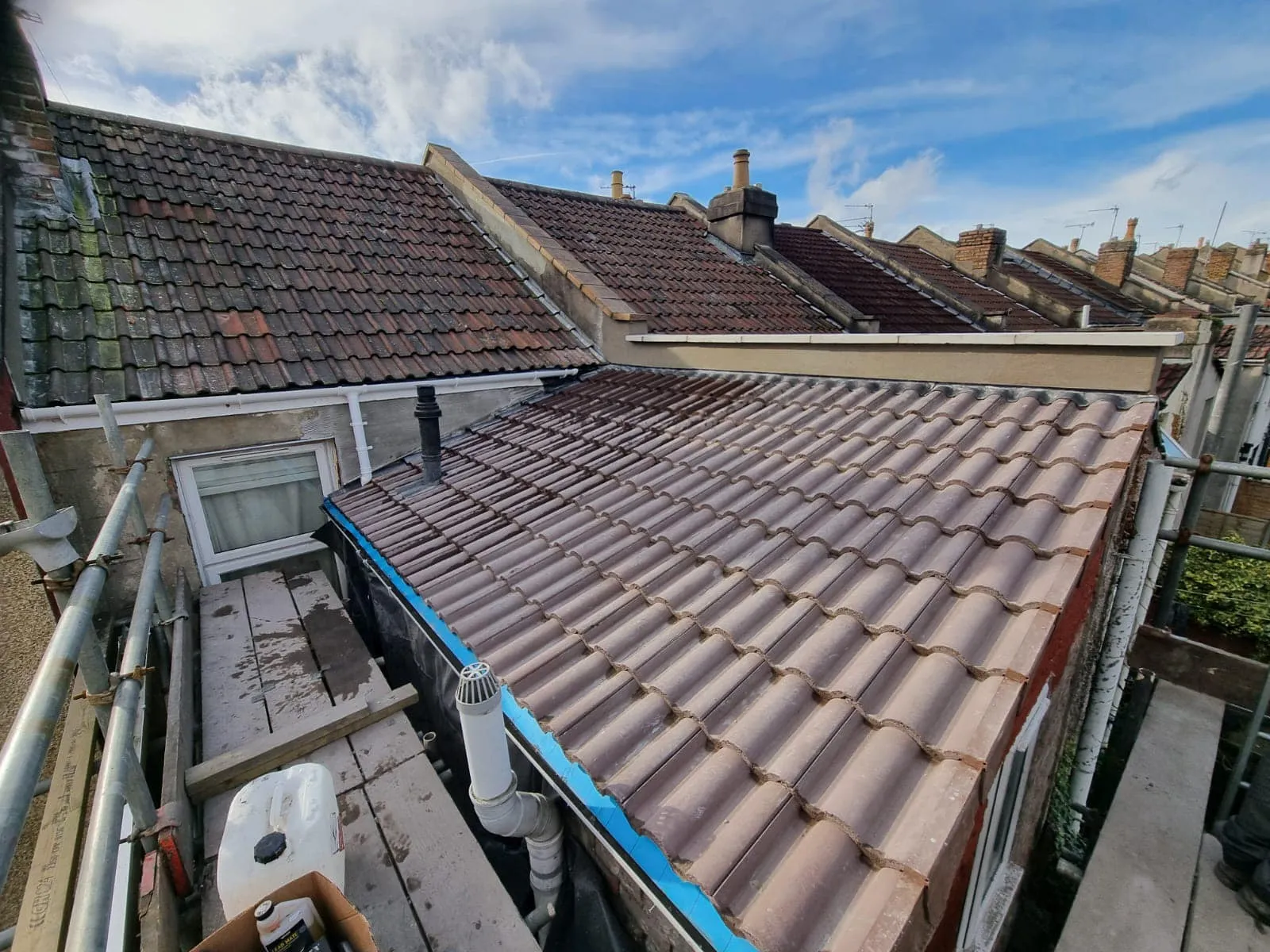 The roof of a house with a blue tape on it.